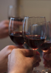 три поднятых бокала с красным вином