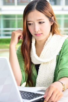 симпатичная девушка увлеченно  работает за ноутбуком